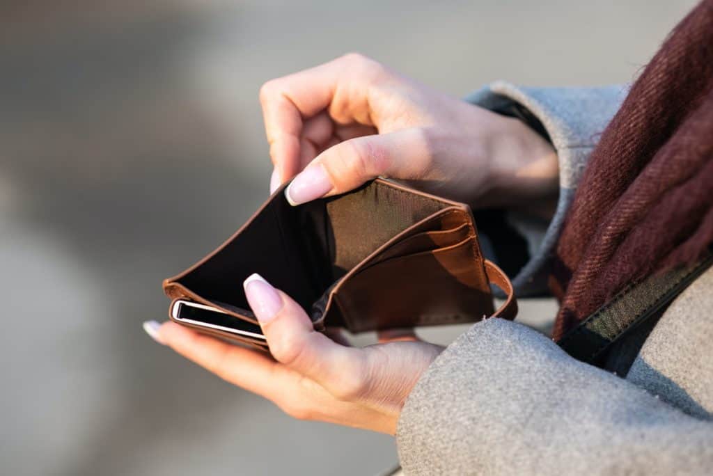 closeup of woman's hands holding a wallet with no money inside